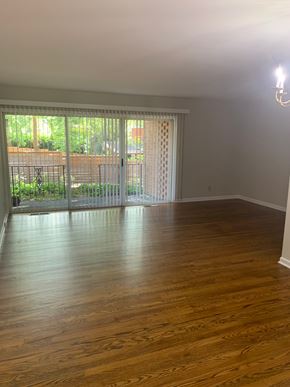 Raleigh apartment for rent - A room with wooden floors and a sliding glass door leading to a backyard.