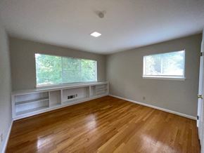Raleigh apartment for rent - an empty room with a wood floor and two windows
