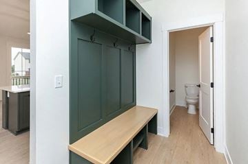 Waukee house for rent - A kitchen with a bench and a toilet in the background.