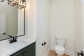 Waukee house for rent - A white toilet sits next to a sink in a bathroom.