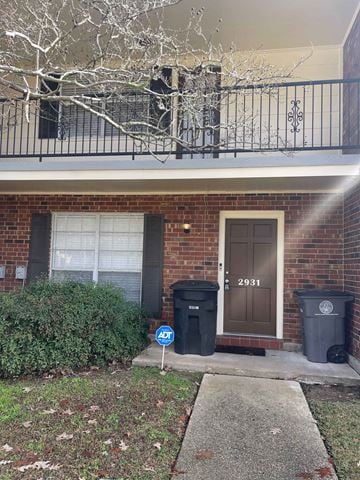 Baton Rouge house for rent - a brick house with a brown door and a balcony