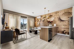 Calgary apartment for rent - A modern kitchen with a wooden island and a dining area with a table and chairs.