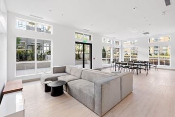 Langley apartment for rent - A modern living room with a grey sofa and a glass door.