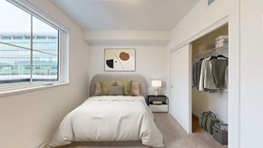 Langley apartment for rent - A bedroom with a large bed and a small nightstand with a lamp.