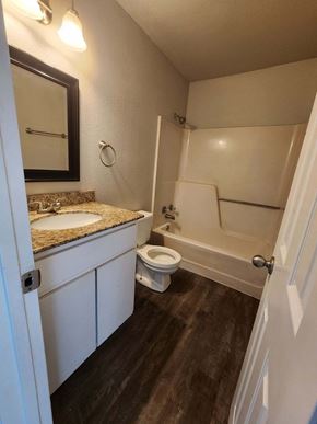 Hearne apartment for rent - A bathroom with a toilet, sink, and mirror.