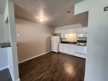 Hearne apartment for rent - A kitchen with white cabinets and a wooden floor.