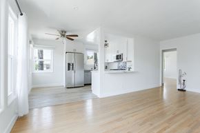 Los Angeles apartment for rent - an empty living room with a kitchen and a ceiling fan