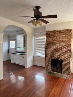Atlanta apartment for rent - A room with a fireplace and a ceiling fan.