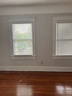 Atlanta apartment for rent - A room with two windows and wooden floors.