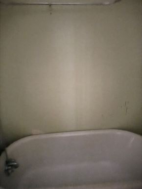 Atlanta apartment for rent - A white bathtub with a silver faucet is in the corner of a bathroom.