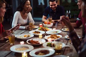 Clarkston apartment for rent - Group of young people socializing and eating food outdoors at a pet-friendly community, enjoying a friendly and welcoming atmosphere.