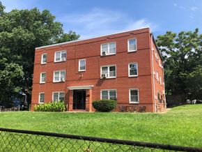 Washington apartment for rent - a red brick building on a hill with a fence