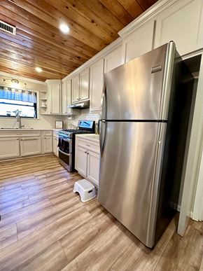 Lafayette house for rent - a kitchen with a stainless steel refrigerator and white cabinets