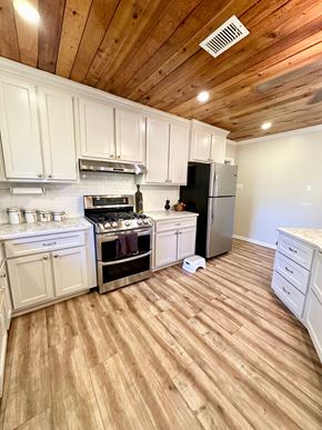 Lafayette house for rent - a kitchen with a wooden floor and white cabinets