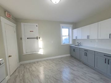 Elizabeth apartment for rent - an empty kitchen with white cabinets and a window