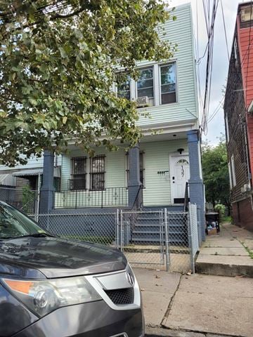 Jersey City apartment for rent - A car is parked in front of a blue house.