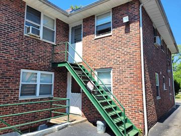 South Orange apartment for rent - A red brick house with a green staircase.