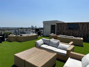 Westwood apartment for rent - a roof top lounge area with couches and tables on a rooftop