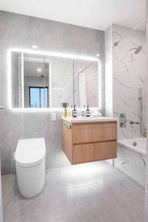 Woodside apartment for rent - a bathroom with a toilet and a vanity with a mirror