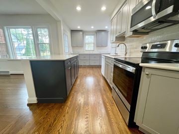 Louisville house for rent - A kitchen with black appliances and wooden floors.
