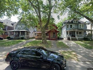 Cleveland house for rent - A black car is parked on a street in front of a house.