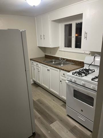 Akron apartment for rent - A kitchen with a stove, sink, and cabinets.