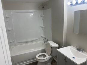 Akron apartment for rent - A white toilet sits next to a bathtub in a bathroom.