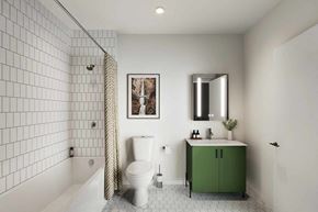 Erie apartment for rent - A white tiled bathroom with a green cabinet and a white toilet.