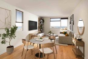 Erie apartment for rent - A living room with a table, chairs, and a television.