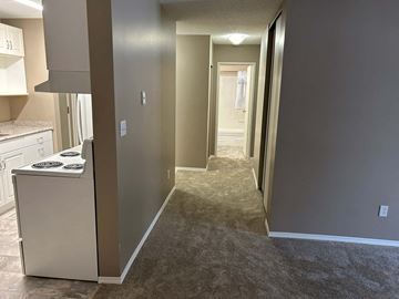 Prince Albert house for rent - a renovated kitchen and hallway with a white stove and refrigerator