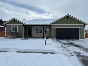 Bozeman house for rent - a house in the snow with a garage door