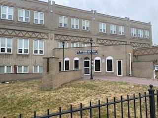 Jersey City apartment for rent - a large brick building with a yard in front of it