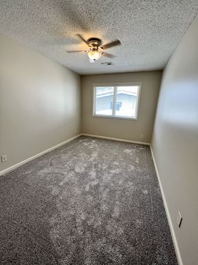 Lincoln apartment for rent - an empty bedroom with a ceiling fan and a window