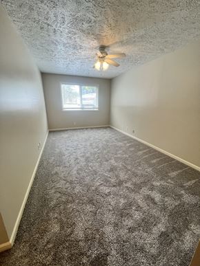 Lincoln apartment for rent - an empty bedroom with carpet and a ceiling fan