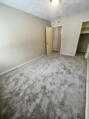 Lincoln apartment for rent - an empty living room with gray carpet and a door to a closet