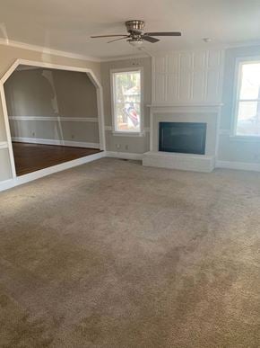 Cary house for rent - A room with a fireplace and a ceiling fan.