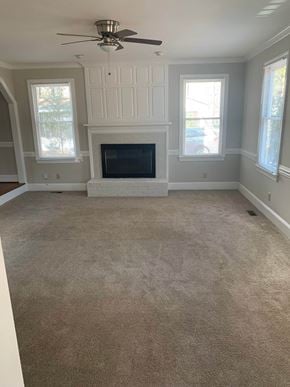 Cary house for rent - A living room with a fireplace and a ceiling fan.