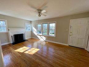 Raleigh house for rent - an empty living room with a fireplace and a ceiling fan