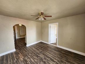 Harrah house for rent - an empty living room with wood floors and a ceiling fan