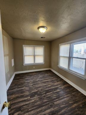 Harrah house for rent - an empty room with wood floors and two windows