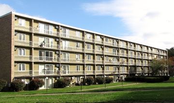 Cuyahoga Falls apartment for rent - a large apartment building with balconies and a lawn in front