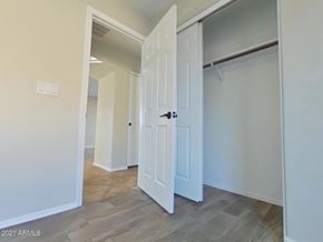 Buckeye house for rent - a bedroom with two closets and a door into a hallway
