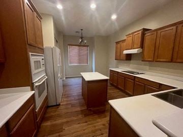 Buckeye house for rent - a kitchen with wooden cabinets and a refrigerator