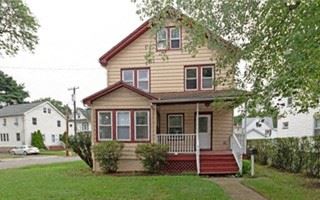 Dunellen apartment for rent - a yellow house with a red porch and a tree