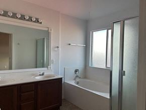 Killeen house for rent - a bathroom with a tub and a sink and a mirror