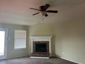 Killeen house for rent - a living room with a fireplace and a ceiling fan