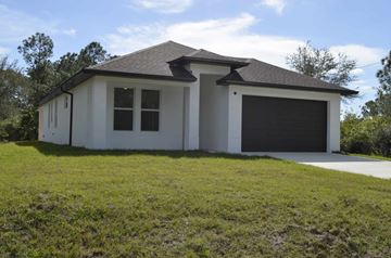 Lehigh Acres house for rent - a white house with a garage and a lawn