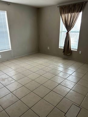 Killeen house for rent - an empty living room with tiled flooring and two windows