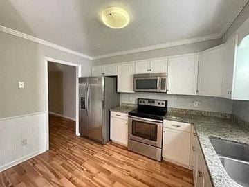 Raleigh house for rent - a kitchen with stainless steel appliances and a wooden floor