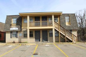 Hattiesburg apartment for rent - the front of an apartment building with stairs and a balcony